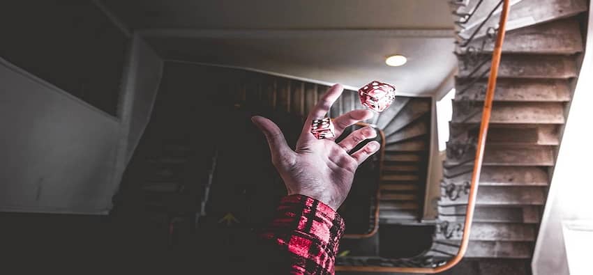 photo of man's hand throwing two dices