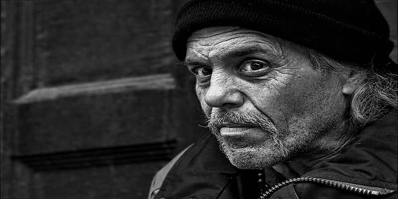 gray photo of sad homeless man