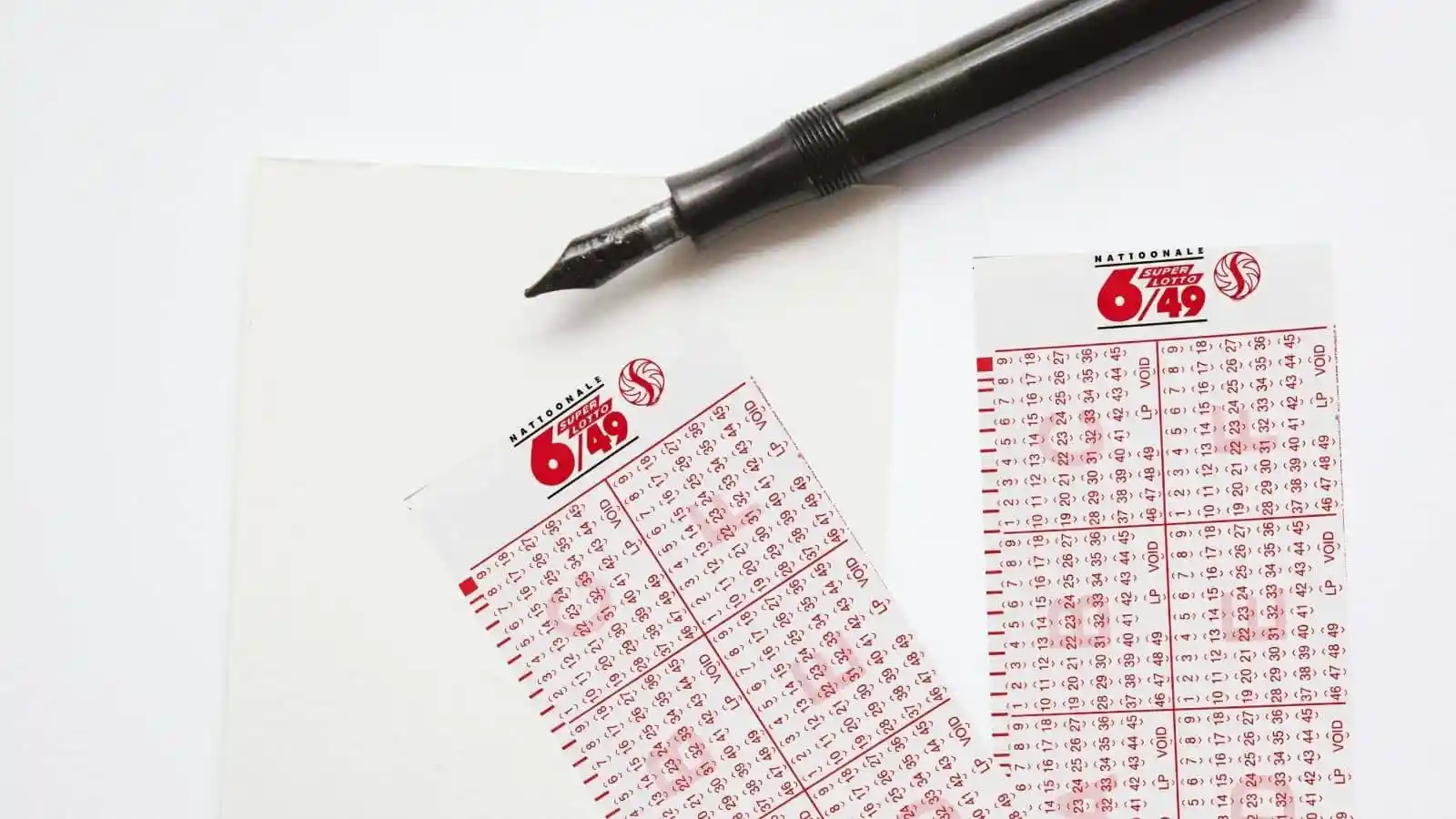 classic black pen, a piecie of paper and super lotto philippines lottery tickets