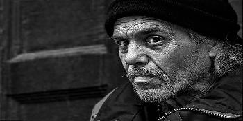 gray photo of sad homeless man